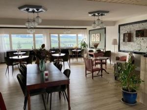 ein Wohnzimmer mit Tischen und Stühlen sowie ein Esszimmer in der Unterkunft Bed & Breakfast Weisser Stein in Schmallenberg