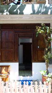 a wooden entry door to a house with a tree at Jogja ethnic house in Yogyakarta
