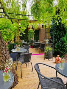 a patio with tables and chairs on a wooden deck at Pear Tree Cottage in Bishop Auckland