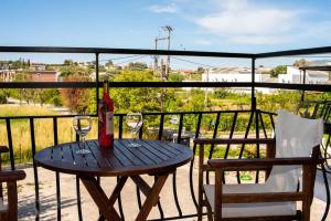 a wooden table with wine glasses on a balcony at Sofia Studios in Laganas