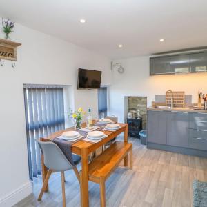 a kitchen and dining room with a wooden table and chairs at Pear Tree Cottage in Bishop Auckland