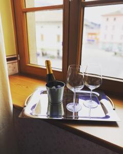 un vassoio con una bottiglia di vino e due bicchieri di Residenza d'Epoca Albergo Grimani ad Ampezzo