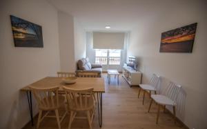 a dining room and living room with a table and chairs at Duerming Ría de Viveiro in Viveiro