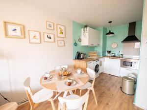a kitchen and dining room with a table and chairs at Apt 2/4 pers. Arcachon + Parking / Le Perchoir in Arcachon