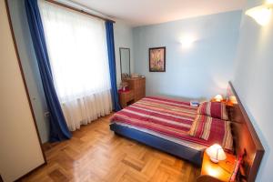 1 dormitorio con cama y ventana grande en Apartments Valdepian, en Umag