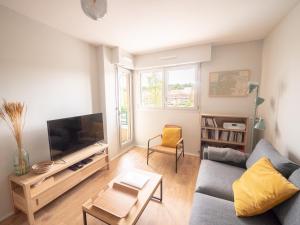 a living room with a couch and a flat screen tv at Apt 2/4 pers. Arcachon + Parking / Le Perchoir in Arcachon