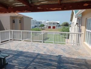 a balcony with a white fence and a patio at Sea Breeze in Stilbaai