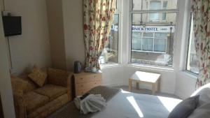 ein Wohnzimmer mit einem Sofa und einem Fenster in der Unterkunft Lynwood Hotel in Blackpool