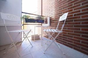 duas cadeiras e uma mesa em frente a uma parede de tijolos em Colours Apartamento em Oviedo