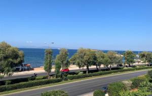 a road next to the ocean with trees and a street at Galini Palace in Athens