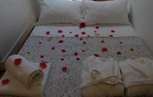a bed with red hearts on it with towels on it at WW Hostel & Suites in Coimbra
