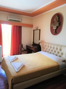 a bedroom with a large bed and a desk at Galini Palace in Athens