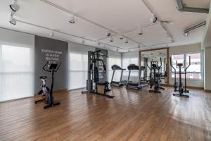 a gym with several treadmills and exercise bikes in a room at Studio Bela Vista Teatro Renault in Sao Paulo