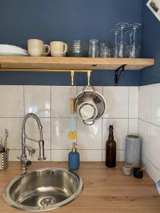 a kitchen counter with a sink and a pot rack at Bastide du Soldat in Abreschviller