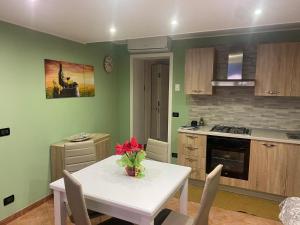 una cocina con una mesa blanca con un jarrón de flores. en Green House di Ingoglia, en Marsala