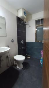 a bathroom with a toilet and a sink at Sunspot -Entire Villa Apartment in Ujjain