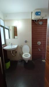 a bathroom with a white toilet and a sink at Sunspot -Entire Villa Apartment in Ujjain