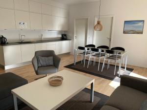 a living room with a table and chairs and a kitchen at Skagen Havn Lejligheder in Skagen