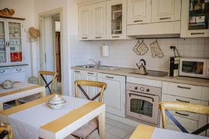 a kitchen with white cabinets and a table and a sink at S'ARD Guest House Sassari in Sassari