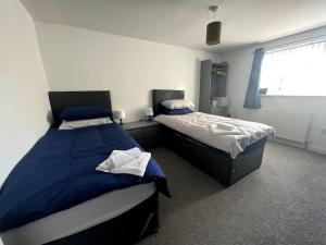 a bedroom with two beds and a window at West End House • Sleeps 8 in Leicester