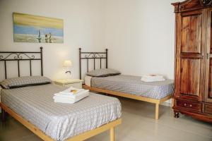 a bedroom with two beds and a dresser at S'ARD Guest House Sassari in Sassari