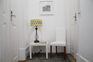 a white room with a table and a chair and a lamp at WW Hostel & Suites in Coimbra