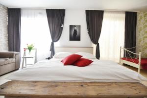a bedroom with a large white bed with red pillows at Apartments Kokolo in Šibenik