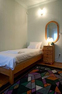- une chambre avec un lit, un miroir et un tapis dans l'établissement Kis Tisza fishing guest house, à Tiszaug