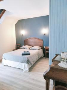 um quarto com uma cama com uma cabeceira de madeira em La Ferme de Plénoise Chambres d'hôtes 