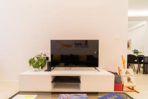una sala de estar con TV en un centro de entretenimiento blanco en Gran Vía Doña Casilda Park by Next Stop Bilbao, en Bilbao