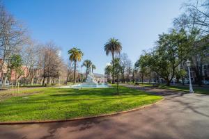 a park with palm trees and a statue in the middle at Gran Vía Doña Casilda Park by Next Stop Bilbao in Bilbao