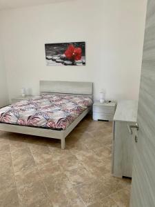um quarto com uma cama com uma flor vermelha em CASA GIULIA em Olbia