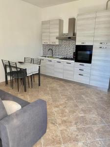 uma cozinha com mesa e cadeiras e uma cozinha com armários brancos em CASA GIULIA em Olbia