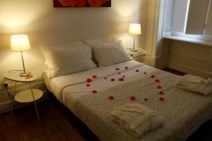 a bedroom with a bed with red roses on it at WW Hostel & Suites in Coimbra