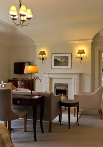 a living room with a table and a fireplace at Tickton Grange Hotel in Beverley