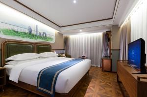 北京市にあるNostalgia S Hotel Beijing CCTVの大型ベッド1台、薄型テレビが備わるホテルルームです。