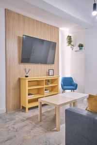 a living room with a tv on a wall at Dadá Coliving & Rooms by Serendipia Turismo in Santiago de Compostela