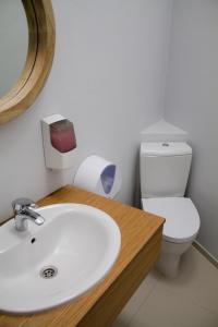 a bathroom with a white sink and a toilet at WW Hostel & Suites in Coimbra