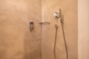 una doccia in bagno con telefono a parete di Hostal Aigua Clara a Playa Migjorn