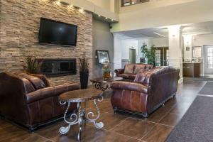a living room with leather furniture and a fireplace at Comfort Inn & Suites in Fort Saskatchewan