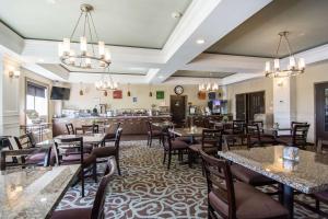 um restaurante com mesas e cadeiras e um bar em Comfort Inn & Suites em Fort Saskatchewan