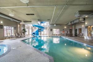 a swimming pool with a slide in a building at Comfort Inn & Suites in Fort Saskatchewan