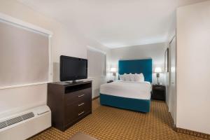 a hotel room with a bed and a flat screen tv at MainStay Suites Chattanooga Hamilton Place in Chattanooga