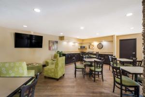ein Restaurant mit Tischen und Stühlen und einem Flachbild-TV in der Unterkunft MainStay Suites Chattanooga Hamilton Place in Chattanooga