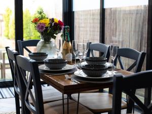 a wooden table with glasses and a vase with flowers at Trinity Cottage in Shottery +17 photos