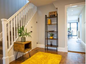 a living room with a staircase and a yellow rug at Trinity Cottage in Shottery