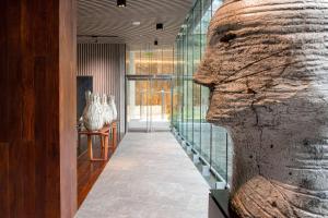 a glass walled hallway with a sculpture of a face at Hyatt Centric San Isidro Lima in Lima