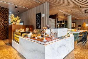 un restaurant avec un comptoir où vous trouverez des pâtisseries dans l'établissement Hyatt Centric San Isidro Lima, à Lima