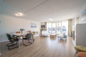 UitgeestにあるMeerzicht 70 - Vakantiehuis aan het water!のテーブルと椅子のある広いリビングルーム