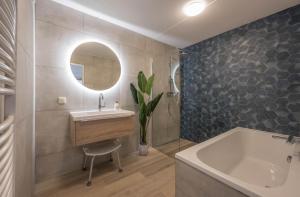 UitgeestにあるMeerzicht 70 - Vakantiehuis aan het water!の洗面台、浴槽、鏡のあるバスルーム +35枚の写真